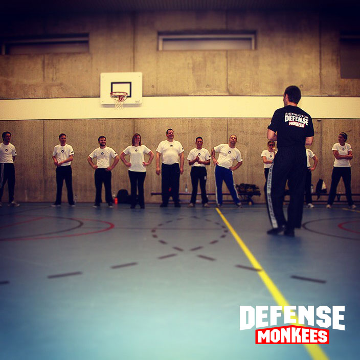 Groepsles Krav Maga zelfverdediging bij DefenseMonkees, waar een instructeur een groep cursisten traint in praktische zelfverdediging in de sportschool.