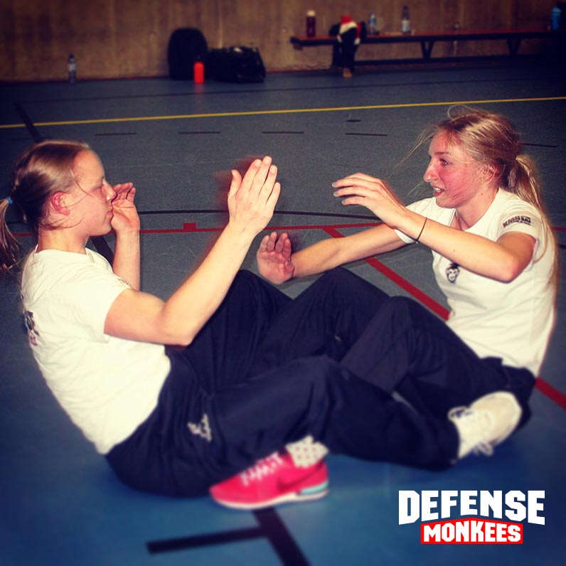 Twee cursisten trainen samen tijdens een Krav Maga groepsles bij DefenseMonkees, met focus op zelfverdediging, samenwerking en fysieke weerbaarheid in de sportschool.